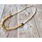 Choker with square brass beads and cream colored rondelle and round shell beads with gold hook clasp